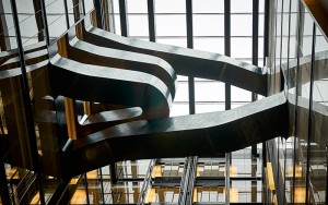 Staircase in blackened stainless steel with over-wax finish for Google, 6 Pancras Square, London, UK - Architects: AHMM - Main contractor: ISG - Staircase fabrication, installation and finishing: John Desmond Ltd - Structural engineers for John Desmond Ltd: AECOM - Showing view from below the stairs. Photography by Tim Soar