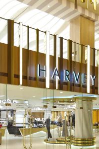 Harvey Nichols, The Avenues, Kuwait exterior and interior fascia and interior trim in Double Stone Steel PVD colored stainless steel Royal Gold Sandblasted