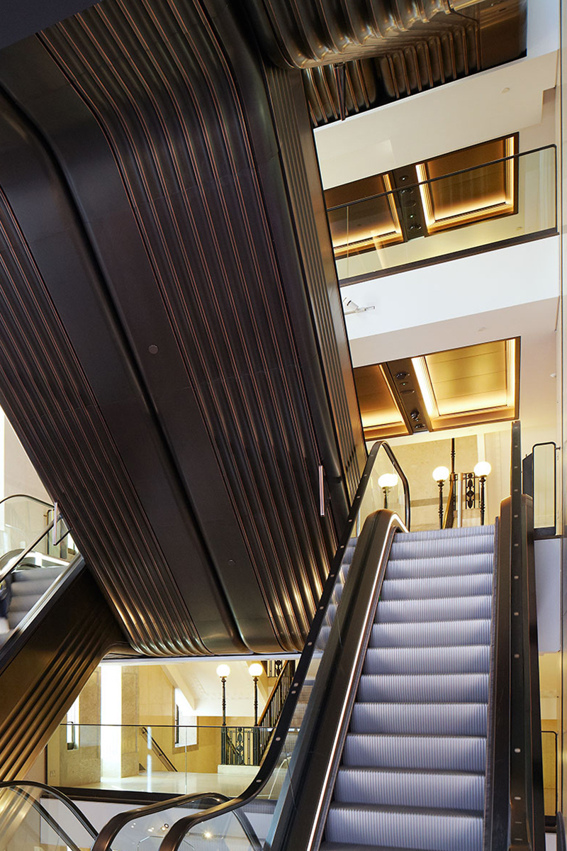 Knightsbridge store, London, UK renovated escalator hall in an Art Deco palette of Double Stone Steel PVD colored stainless steel in Almond Gold Mirror, Black is Black Brush and custom color Nickel Bronze Mirror Knightsbridge store, London, UK renovated escalator hall in an Art Deco palette of Double Stone Steel PVD colored stainless steel in Almond Gold Mirror, Black is Black Brush and custom color Nickel Bronze Mirror