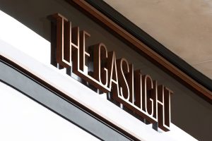 Signage to entrance of The Gaslight, a refurbished Edwardian warehouse converted to offices, restaurant and gym, Rathbone Street, London, UK. - Interior designers: Bureau de Change - Photography: Gilbert McCarragher - Signage lettering in Double Stone Steel PVD colored stainless steel Bronze Brush