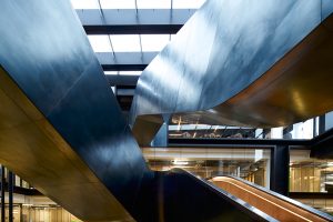 Staircase in blackened stainless steel with over-wax finish for Google, 6 Pancras Square, London, UK - Architects: AHMM - Main contractor: ISG - Staircase fabrication, installation and finishing: John Desmond Ltd - Structural engineers for John Desmond Ltd: AECOM - Showing view from below the stairs. Photography by Tim Soar