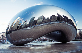 The sculpture Cloud Gate by Anish Kapoor showing the reflected skyline of Chicago in its apparently seamless polished stainless steel surface.
