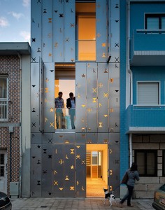 House 77, Portugal illuminated from the interior showing symbols in the stainless steel cladding.