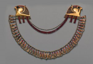 Broad gold collar made in the reign of Thutmose III ca 1479 – 1425 BC. Made from Gold, Carnelian, Obsidian and Glass. Displayed at the Metropolitan Museum, Fifth Avenue. The necklace was a gift from King Thutmose to one of his three wives as indicated by the inscription of his name on the back of one of the falcon heads.