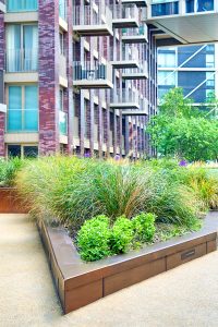 The color of these custom-designed box planters was chosen by the landscape architect to complement the building’s façade and are in Double Stone Steel PVD colored stainless steel Bronze Sandblasted