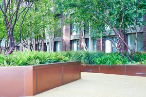 Custom planters in Double Stone Steel PVD colored stainless steel Bronze sandblasted at Embassy Gardens, part of the Ballymore Homes development adjacent to the US Embassy, Nine Elms, Wandsworth, London, UK - Landscape Architect: Camlins; Hyland Edgar Driver - Landscape Designers: In-Ex Landscapes