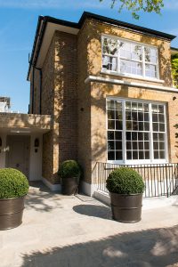 Tub Planters in Double Stone Steel PVD colored stainless steel Gunmetal Sandblasted are co-ordinated with this residential property development’s gates and railings