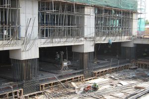 Image from a building site which is being built using the top down construction method, the above ground structure is already finished while the lower part is still due to be infilled with concrete. Image from Engineering Discoveries.