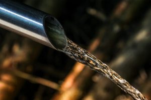 Water flowing through a steel pipe. Precision sizing of metal pipes is done using a production technique known as tube drawing that was first used in the 19th century.