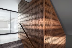 Custom-made screen, used as full-height stair balustrading and for feature walls - throughout the building, in Double Stone Steel PVD colored stainless steel Bronze Brush. - The Gaslight Building, Rathbone St, London UK - Interior Designer: Bureau de Change