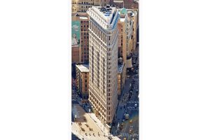Aerial view of the Flatiron building at the corner of Fifth Avenue, Broadway, and East 22nd Street. Although this triangular prism resembles the shape of a clothes iron the building derives its name from the Flatiron District neighborhood in Manhattan.