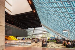 Seattle Central Library. Architects: OMA (Rem Koolhaas + Joshua Prince Ramus) and LMN Architects. Internal view of the lobby-living room. The steel mesh shapes the space of the unstable programmatic platforms of the building. Big size rugs ornamented with vegetal patterns define areas within the space. Image by Hoffman Construction Company.