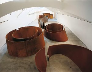 Richard Serra’s Snake alongside the series Torqued Ellipses and Double Torqued Ellipses for “The Matter of Time” exhibition (2004). The installation prompts an exploration of negative space and the material properties of corten steel. Photography by Guggenheim Museum, Bilbao.