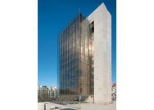 Castelar Building. Architects: Rafael de la Hoz Arderius and Gerardo Olivares. The office space volume cladded in a double skin of glass hangs from the off-centered, travertine-cladded, concrete core at the back. Photography by Duccio Malagamba