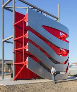 The full-scale mock-up a section of the façade of The Petersen Automotive Museum in red-painted aluminium and wavy ribbons in stainless steel Angel Hair. The red backdrop was clearly changed since the mock up to a perforated finish rather than vertical strips.Image from A.Zahner.